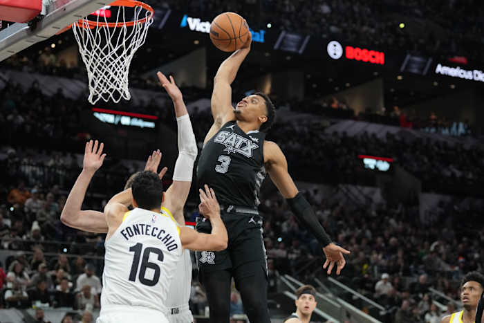 Dec 26, 2023; San Antonio, Texas, USA; San Antonio Spurs forward Keldon Johnson (3) dunks over Utah Jazz forward Simone Fontecchio (16) in the second half at Frost Bank Center.